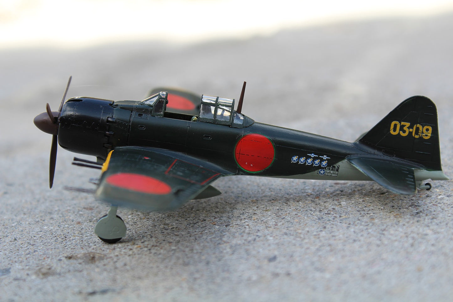 1/72 scale Academy Mitsubishi A6M5c Zero-Sen model kit in green and black with red accents and propeller.